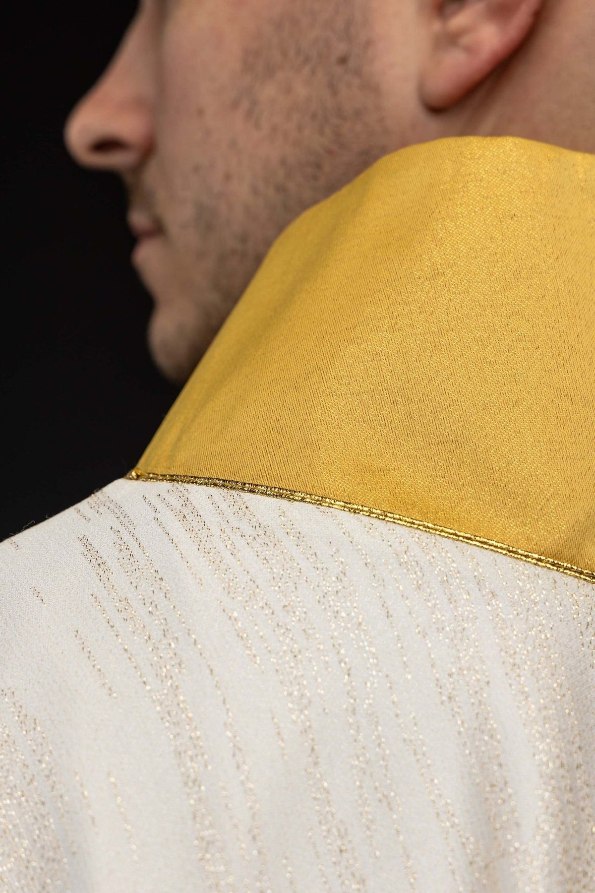 Casula mariana marfim ecru em close-up, mostrando o colarinho dourado e a textura do tecido