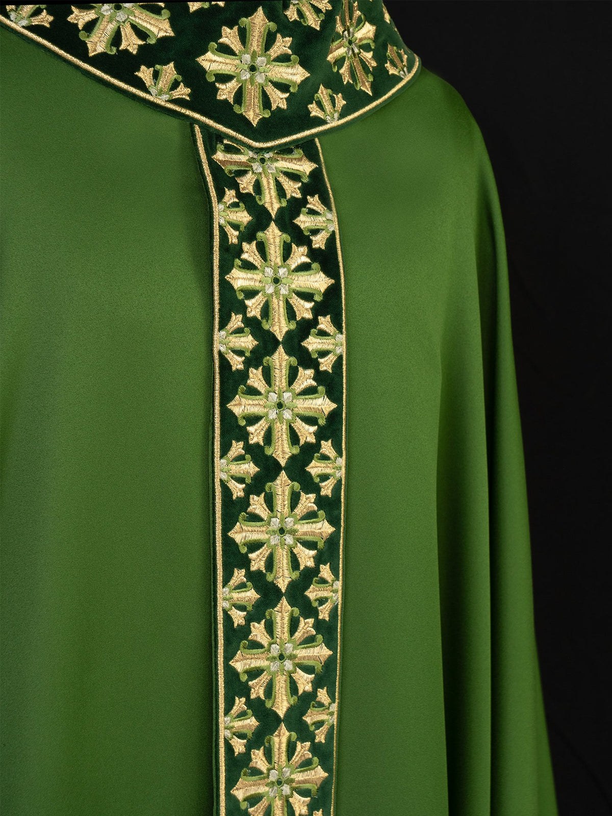 Casula verde em close-up, mostrando bordado brilhante de cruzes douradas