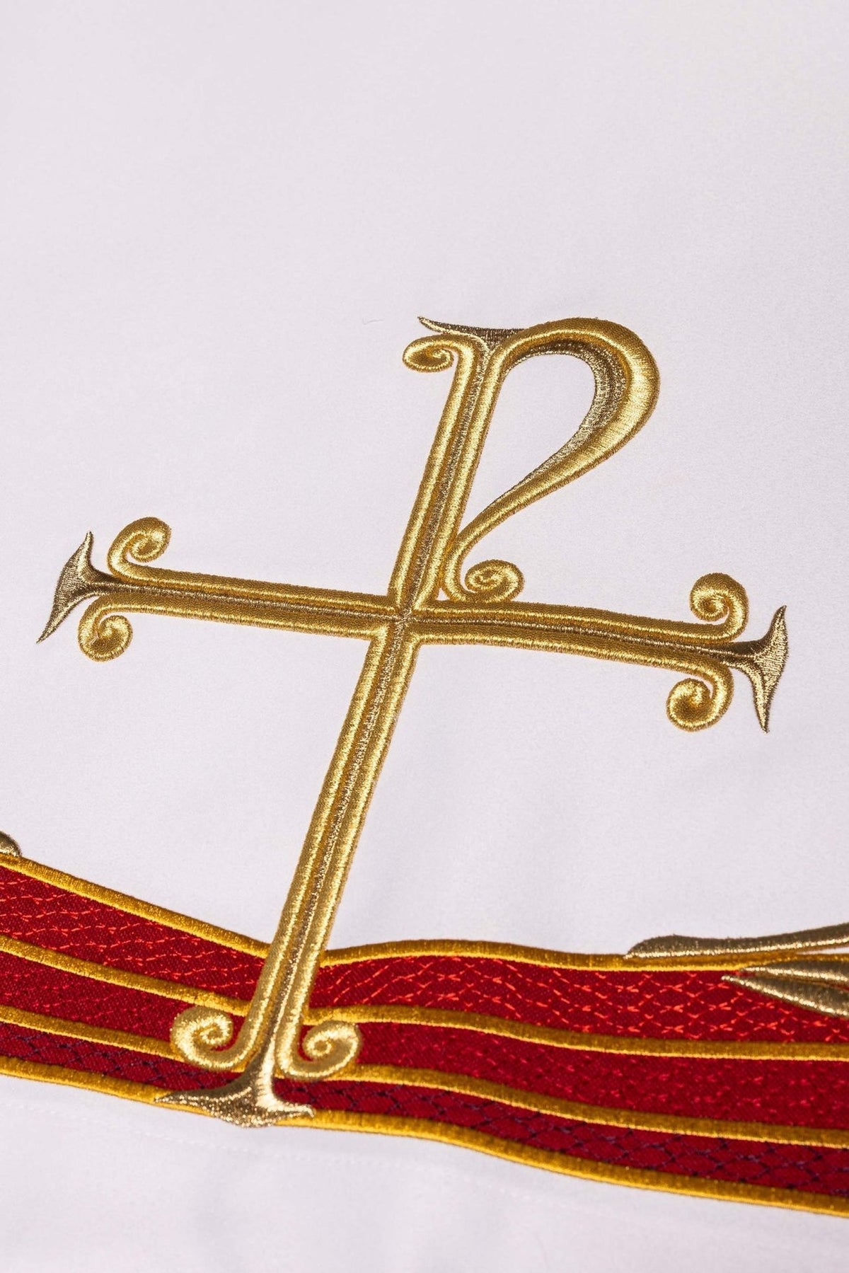 Toalha de altar com símbolo PAX, close-up do bordado dourado sobre faixas vermelhas