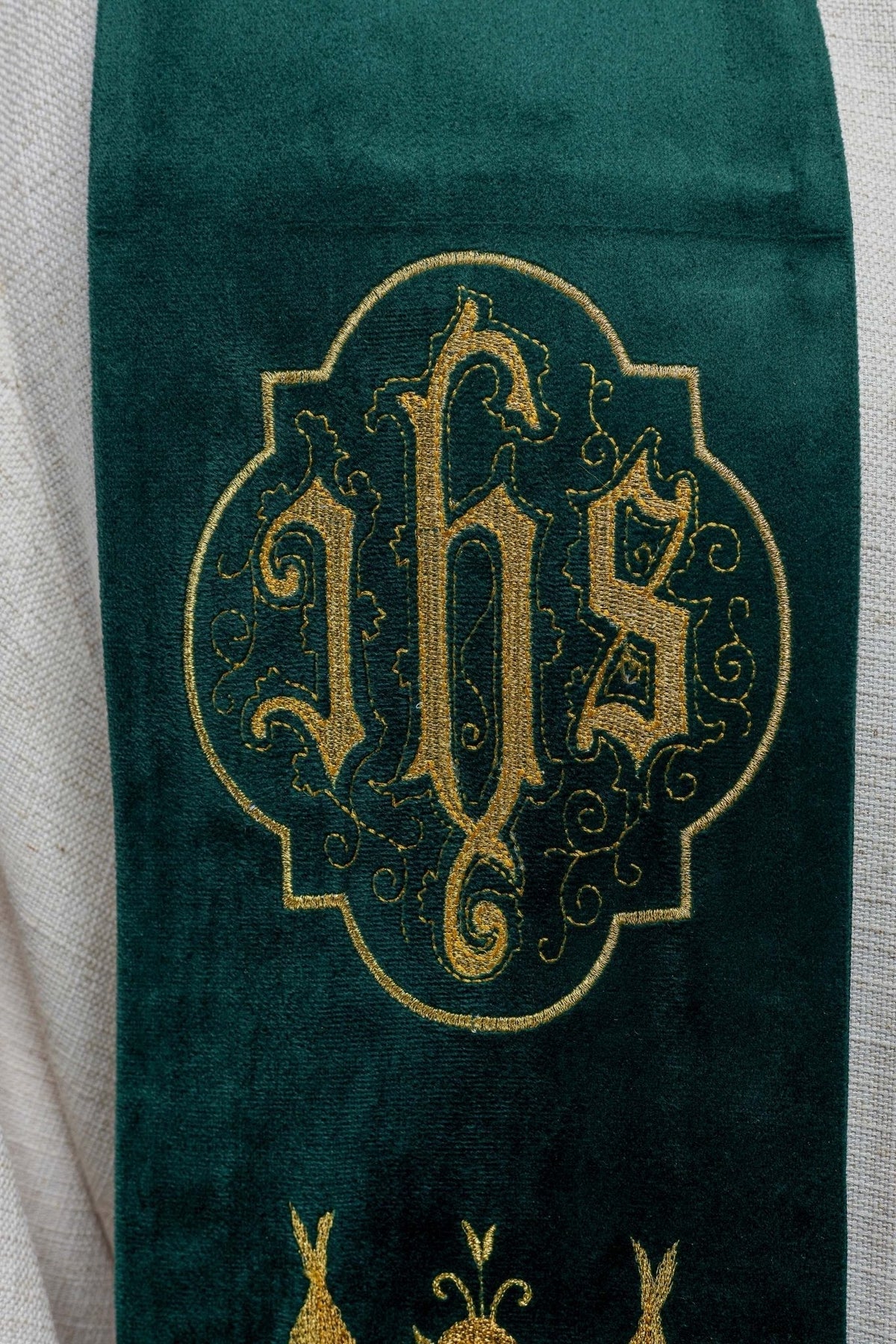 Estola verde com close-up do monograma IHS bordado em dourado