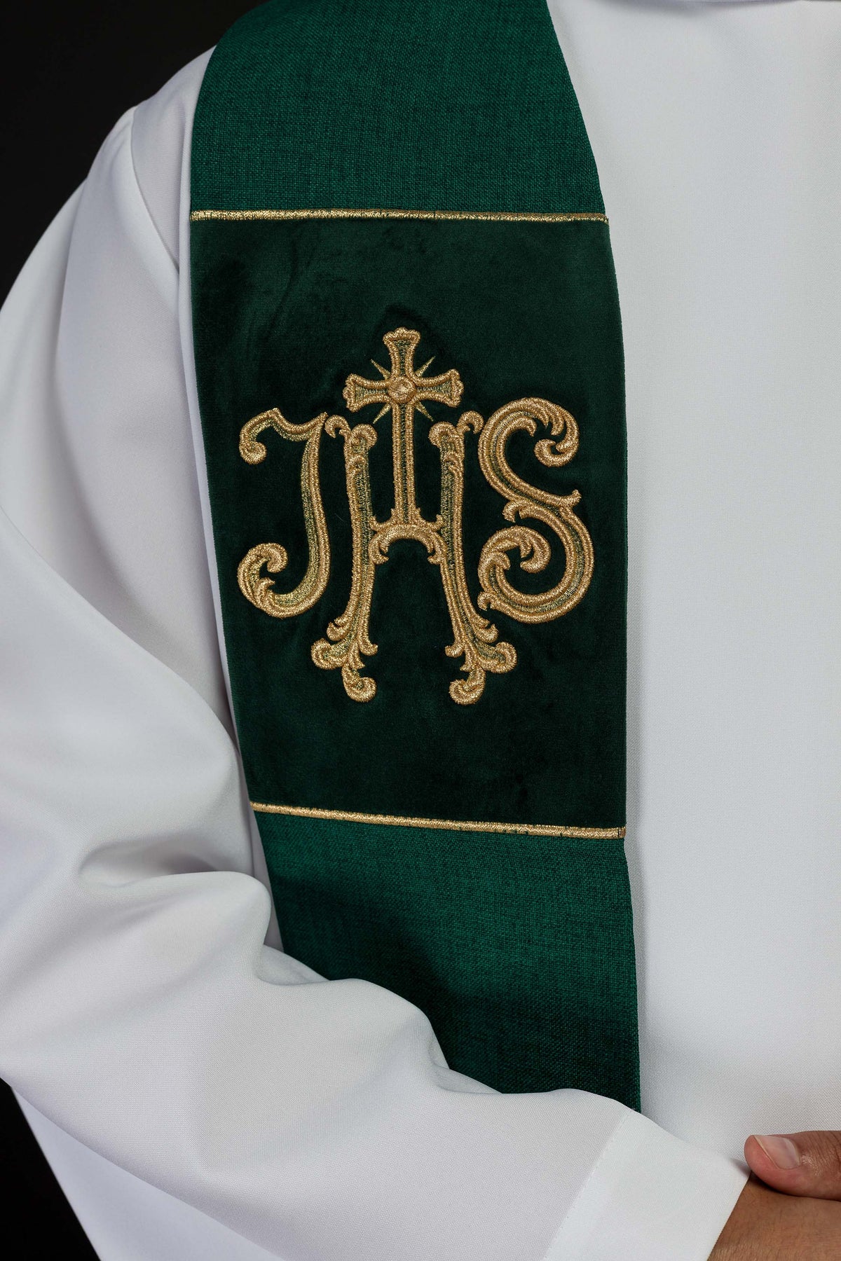 Estola verde de veludo em close, com monograma IHS bordado e linhas douradas