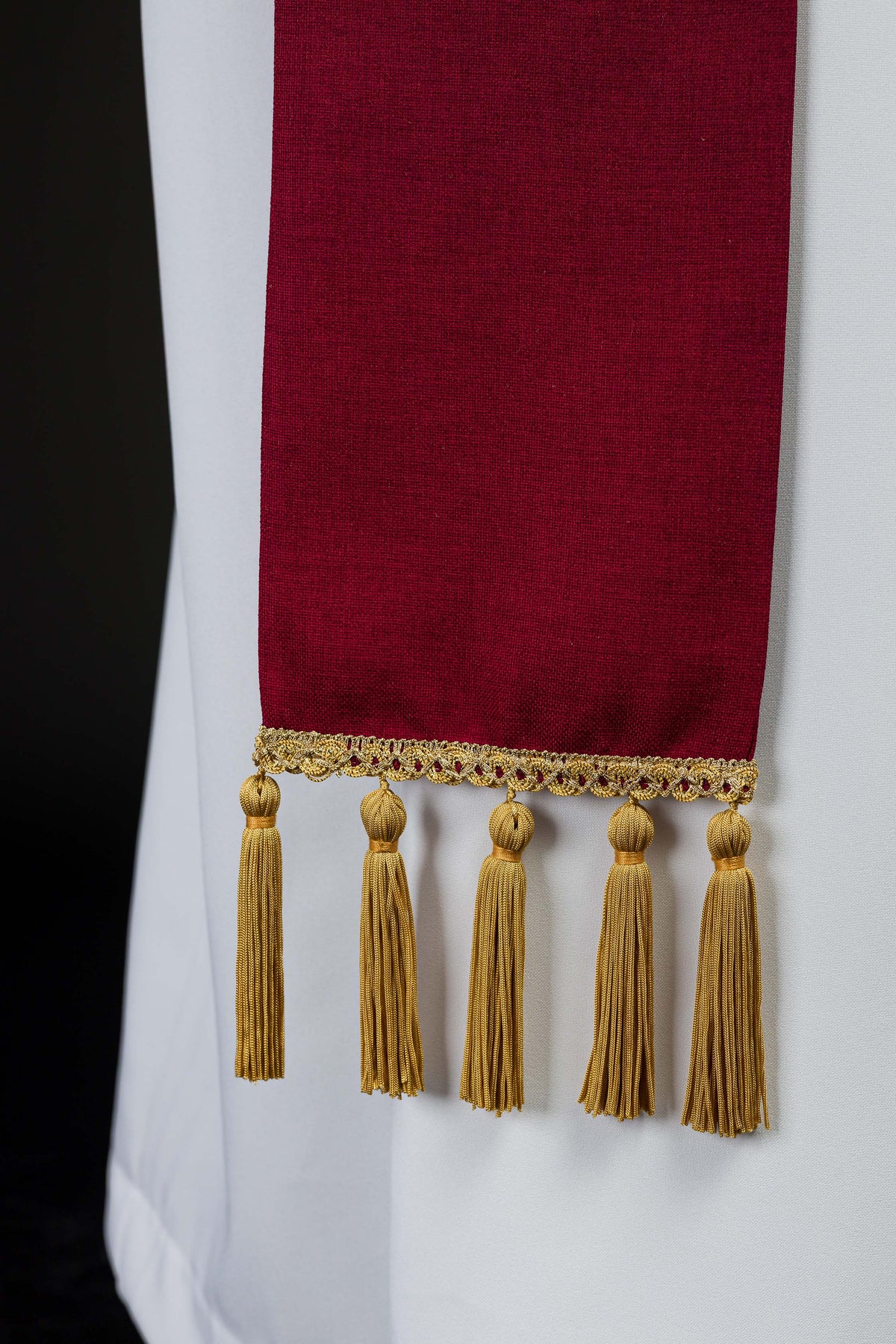 Estola vermelha, close-up da ponta com renda dourada e cinco franjas