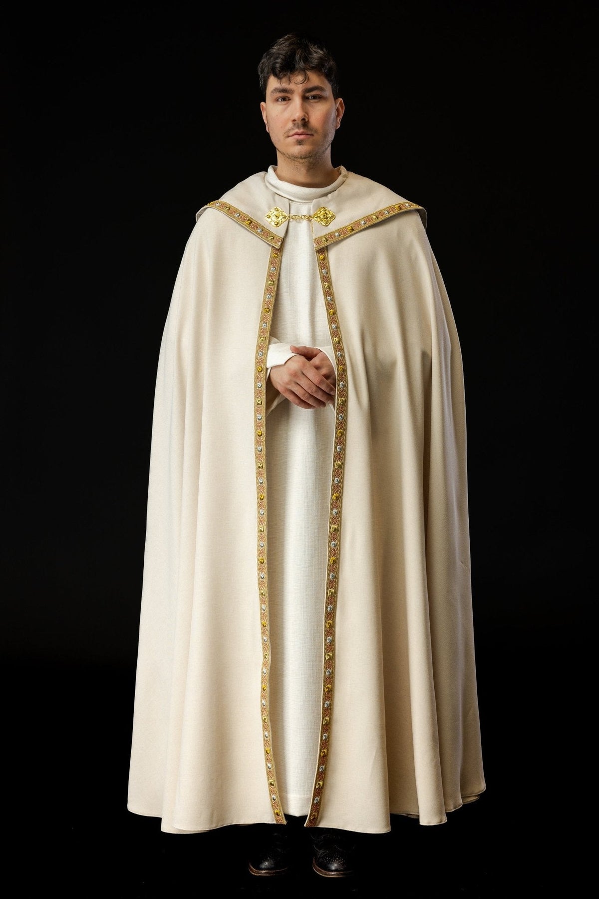 Capa de asperges litúrgica creme vista de frente em corpo inteiro, com galão dourado