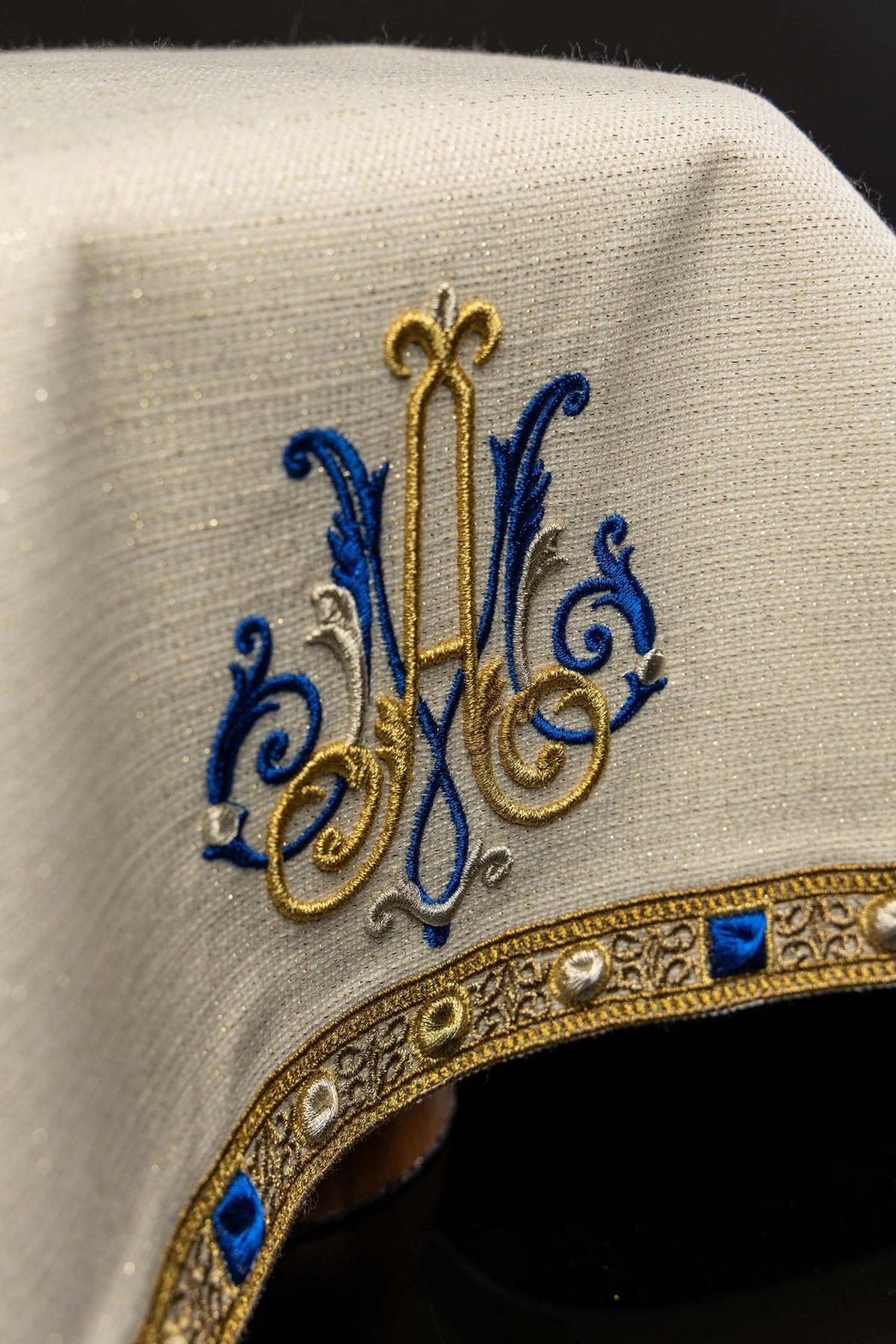 Véu de cálice ecru, close-up do bordado mariano azul, dourado e prateado