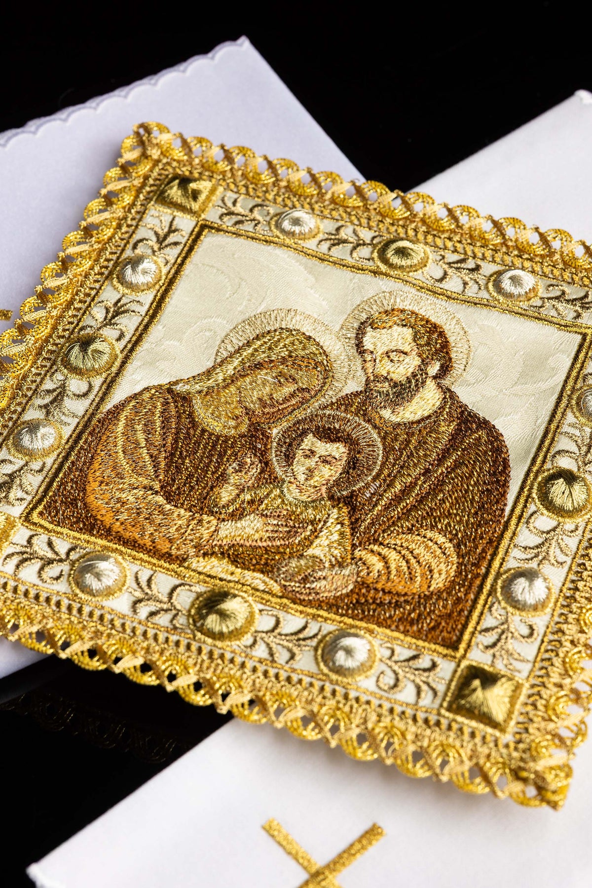 Conjunto de alfaias litúrgicas com close-up da imagem bordada da Sagrada Família