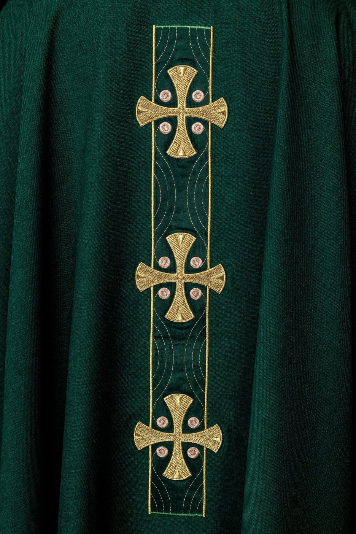 Casula verde com detalhe aproximado dos bordados de cruzes douradas