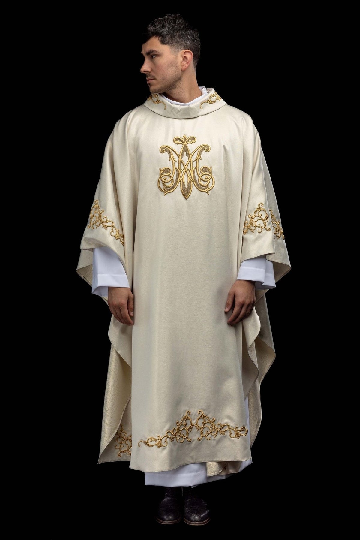 Casula litúrgica marfim ecru, vista frontal com símbolo mariano e barra bordados em dourado